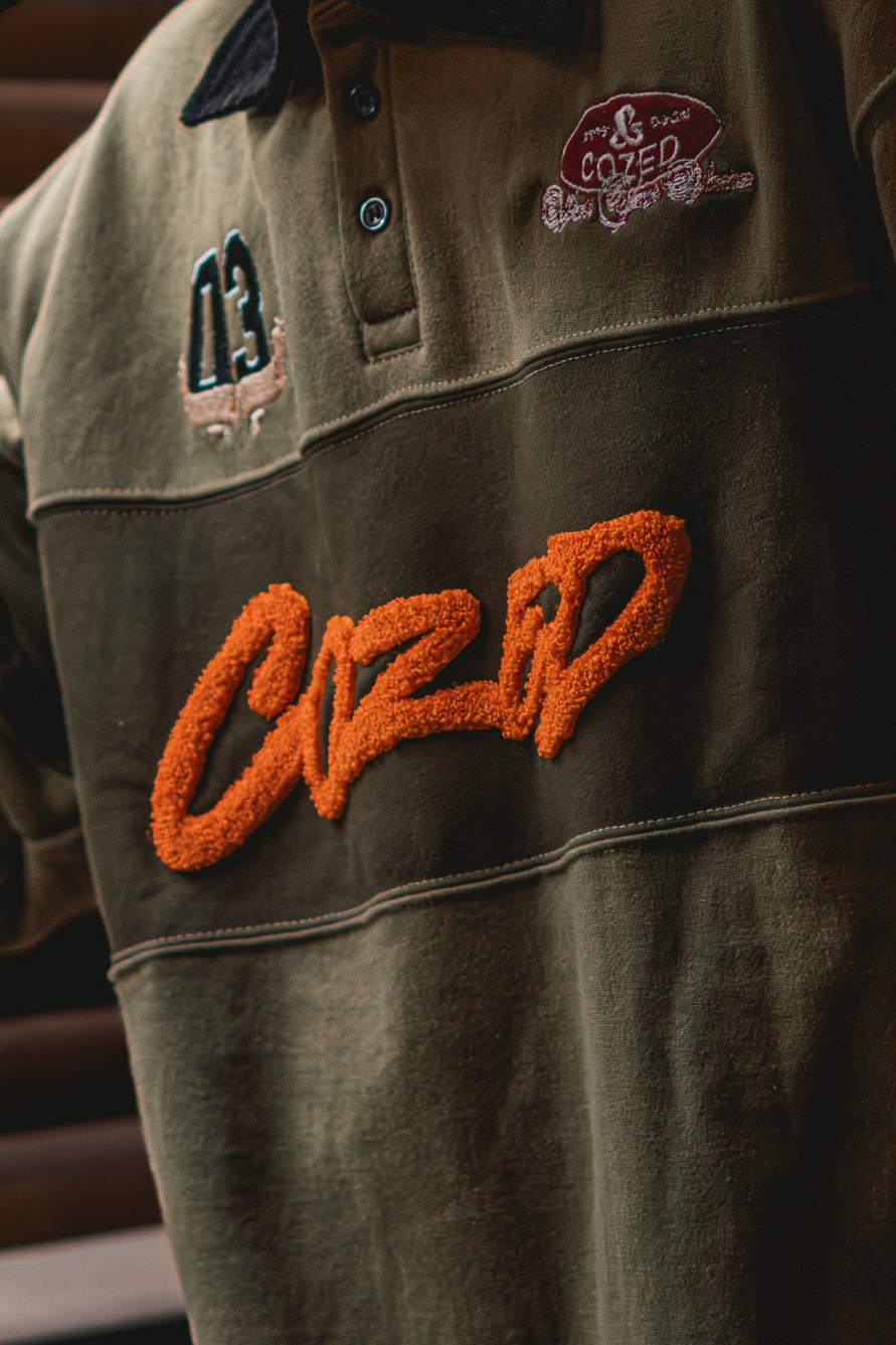Close-up of a jacket with embroidered text and logos on a dark background